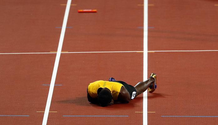 Usain Bolt leżący na bieżni Stadionu Olimpijskiego w Londynie